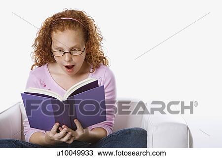 Caucasian female child sitting reading book looking surprised. View Large Photo Image Stock Image - Caucasian female child sitting reading book looking surprised.. Fotosearch