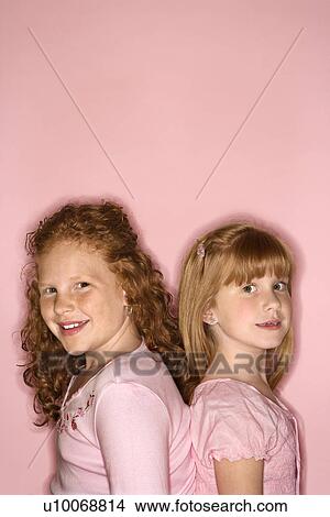 Caucasian female children standing back to back. View Large Photo Image Picture - Caucasian female children standing back to back.. Fotosearch