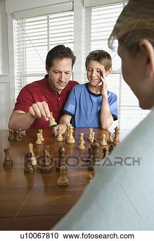 Caucasian mid-adult mother watching mid-adult dad teaching chess to pre-teen son. View Large Photo Image Stock Image - Caucasian mid-adult mother watching mid-adult dad teaching chess to pre-teen son.. Fotosearch