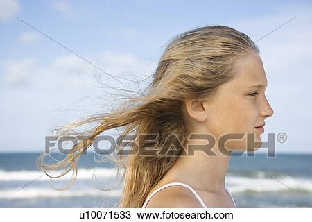Caucasian pre-teen girl on beach with hair blowing in wind. View Large Photo Image Stock Image - Caucasian pre-teen girl on beach with hair blowing in wind.. Fotosearch