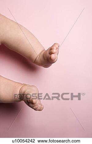 Stock Image - Close up of Asian babys legs and feet.. Fotosearch