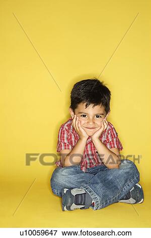 Stock Photo - Filipino male child sitting with head on hands.. Fotosearch