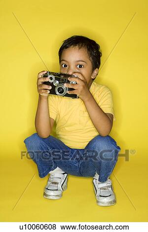 Hispanic male child kneeling with camera. View Large Photo Image Stock Photo - Hispanic male child kneeling with camera.. Fotosearch