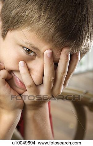 Portrait of Caucasian pre-teen boy with hand partially over face. View Large Photo Image Picture - Portrait of Caucasian pre-teen boy with hand partially over face.. Fotosearch