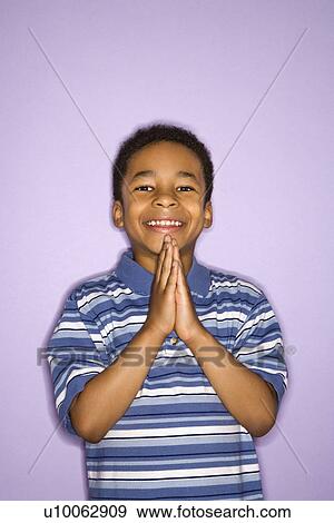 Portrait of young boy with hands together looking at viewer. View Large Photo Image Stock Photo - Portrait of young boy with hands together looking at viewer.. Fotosearch