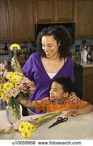 Portrait of young pregnant mother and son arranging flowers. View Large Photo Image Stock Photo - Portrait of young pregnant mother and son arranging flowers.. Fotosearch