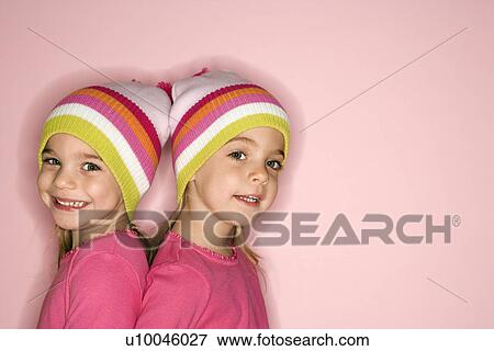 Young female twin Caucasian children standing back to back. View Large Photo Image Stock Photo - Young female twin Caucasian children standing back to back.. Fotosearch