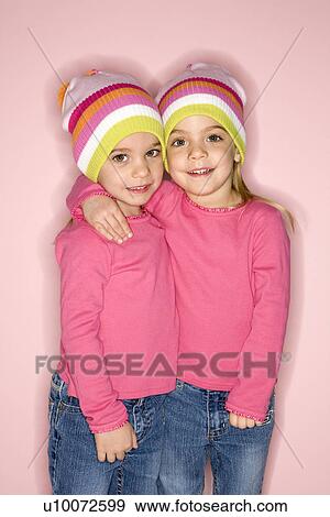 Stock Photo - Young female twin Caucasian children standing together.. Fotosearch