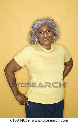 Stock Photo - African American female mature adult standing looking at viewer smiling.. Fotosearch
