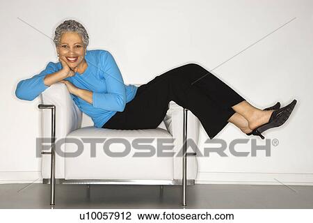 African American mature adult female lying back on chair. View Large Photo Image Stock Image - African American mature adult female lying back on chair.. Fotosearch