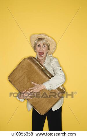 Caucasian mature adult female grasping suitcase. View Large Photo Image Stock Photo - Caucasian mature adult female grasping suitcase.. Fotosearch