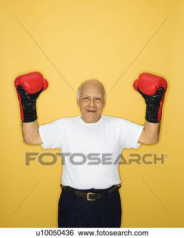 Stock Photograph - Caucasian mature adult male wearing boxing gloves.. Fotosearch