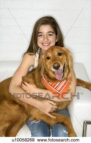 Stock Photo - Female adolescent Caucasian holding Golden Retriever dog.. Fotosearch