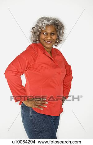 Picture - Mature adult African American female standing looking at viewer smiling.. Fotosearch