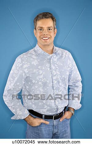 Stock Photography - Mid-adult Caucasian man standing looking at viewer.. Fotosearch