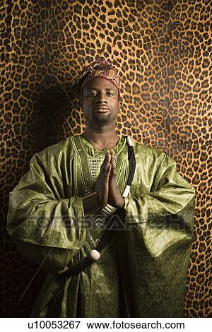Portrait of African- American mid-adult man in prayer wearing traditional African clothing. View Large Photo Image Stock Photo - Portrait of African- American mid-adult man in prayer wearing traditional African clothing.. Fotosearch