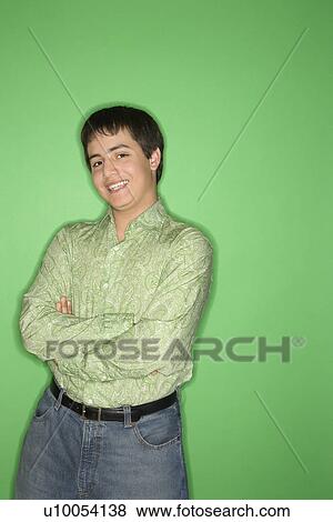 Portrait of Caucasian teen boy smiling with crossed arms standing against green background. l View Large Photo Image Stock Photo - Portrait of Caucasian teen boy smiling with crossed arms standing against green background. l. Fotosearch