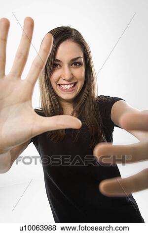 Portrait of young Caucasian female smiling with hands in foreground. View Large Photo Image Stock Photo - Portrait of young Caucasian female smiling with hands in foreground.. Fotosearch