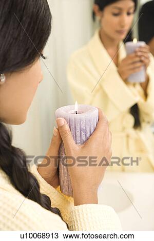 Asian/Indian young woman holding lit candle in front of mirror. View Large Photo Image Stock Image - Asian/Indian young woman holding lit candle in front of mirror.. Fotosearch