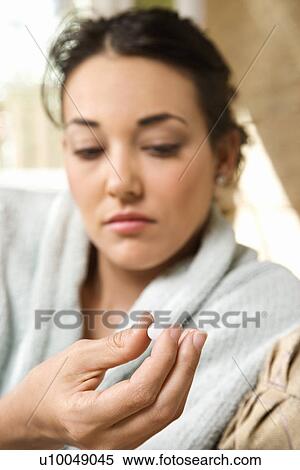 Caucasian/Hispanic young woman in bathrobe holding pill in hand. View Large Photo Image Stock Photography - Caucasian/Hispanic young woman in bathrobe holding pill in hand.. Fotosearch