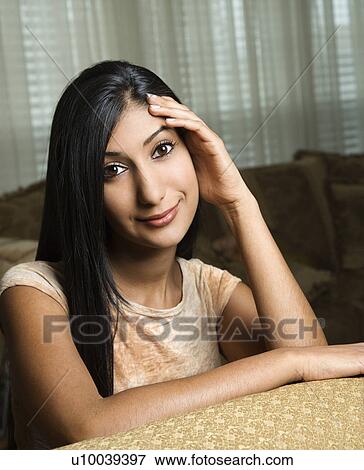 Close up portrait of Asian/Indian young woman sitting on couch. View Large Photo Image Stock Photo - Close up portrait of Asian/Indian young woman sitting on couch.. Fotosearch