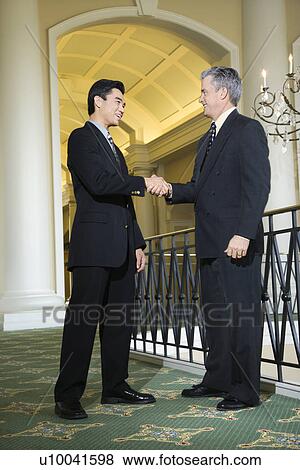 Caucasian prime adult male businessman and Asian prime adult male businessman in hotel. View Large Photo Image Stock Photo - Caucasian prime adult male businessman and Asian prime adult male businessman in hotel.. Fotosearch