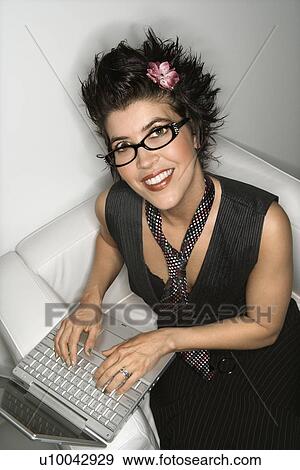 High angle view of Hispanic woman smiling and typing on laptop. View Large Photo Image Stock Photo - High angle view of Hispanic woman smiling and typing on laptop.. Fotosearch