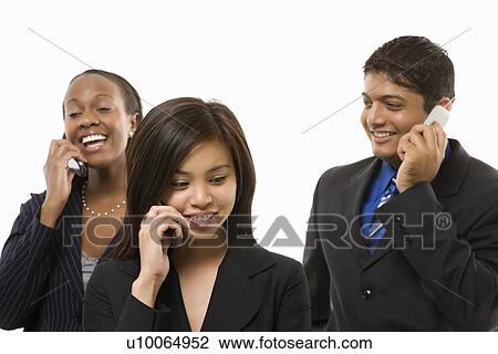 Stock Image - Multi-ethnic businesswomen and businessman standing talking on cell phones.. Fotosearch