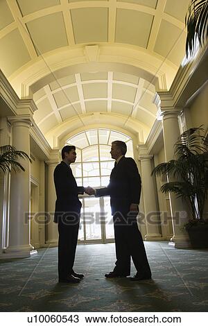 Prime adult Asian and Caucasian businessmen shaking hands. View Large Photo Image Stock Image - Prime adult Asian and Caucasian businessmen shaking hands.. Fotosearch