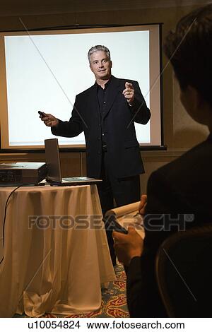 Picture - Prime adult Caucasian businessman giving presentation.. Fotosearch