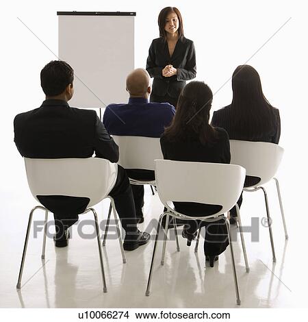 Picture - Vietnamese mid-adult woman standing in front of business group leading presentation.. Fotosearch