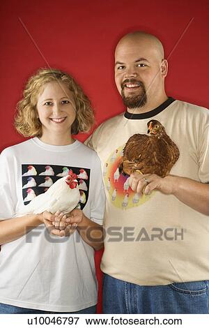 Stock Photo - Caucasian mid-adult man and woman holding chickens.. Fotosearch