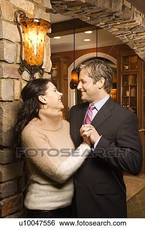 Caucasian woman and Caucasian man holding hands looking at each other and smiling. View Large Photo Image Stock Photograph - Caucasian woman and Caucasian man holding hands looking at each other and smiling.. Fotosearch