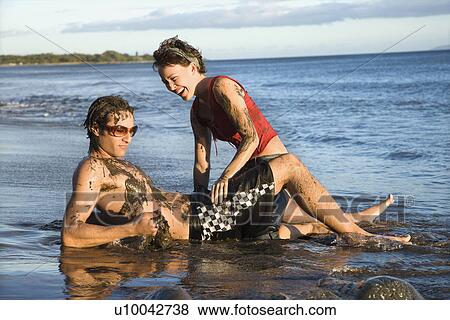 Caucasian young adult couple frolicking on beach. View Large Photo Image Stock Photo - Caucasian young adult couple frolicking on beach.. Fotosearch