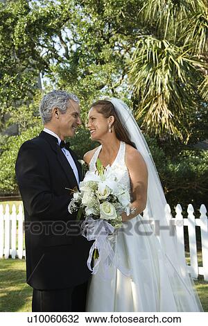 Stock Image - Portrait of bride and groom looking at each other. . Fotosearch