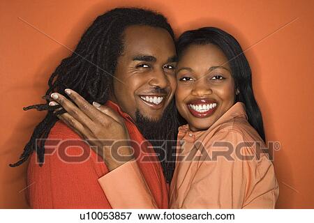 Smiling African-American mid-adult couple wearing orange clothing on orange background. View Large Photo Image Stock Photo - Smiling African-American mid-adult couple wearing orange clothing on orange background.. Fotosearch