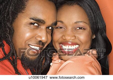 Smiling African-American mid-adult couple wearing orange clothing on orange background. View Large Photo Image Stock Photo - Smiling African-American mid-adult couple wearing orange clothing on orange background.. Fotosearch