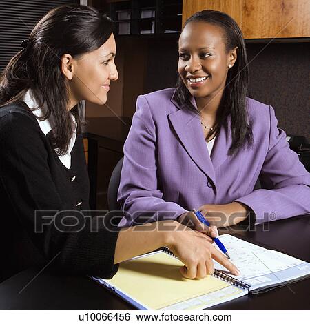 African-American and Indian young adult smiling business women working together in office. View Large Photo Image Stock Photograph - African-American and Indian young adult smiling business women working together in office.. Fotosearch