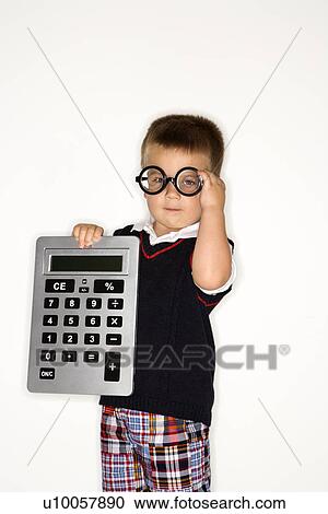 Stock Image - Caucasian male child wearing glasses and holding large calculator.. Fotosearch