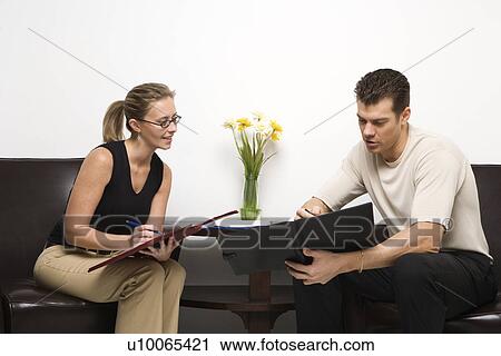 Caucasian mid-adult man and woman sitting looking at portfolios. View Large Photo Image Stock Image - Caucasian mid-adult man and woman sitting looking at portfolios.. Fotosearch
