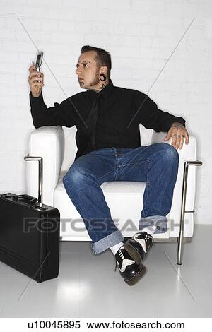Caucasian mid-adult man with tattoos and piercings looking at cell phone with briefcase. View Large Photo Image Stock Photography - Caucasian mid-adult man with tattoos and piercings looking at cell phone with briefcase.. Fotosearch