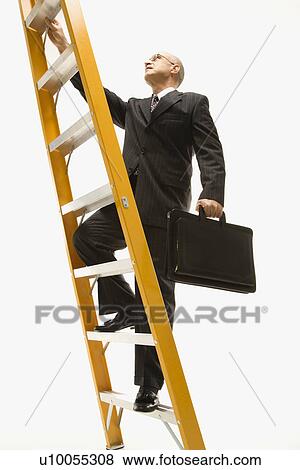 Stock Photo - Caucasian middle-aged businessman climbing ladder carrying briefcase.. Fotosearch