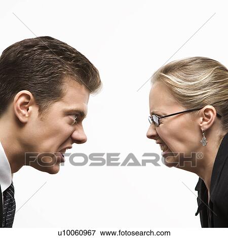 Stock Photo - Close-up of Caucasian mid-adult man and woman staring at each other with hostile expressions.. Fotosearch