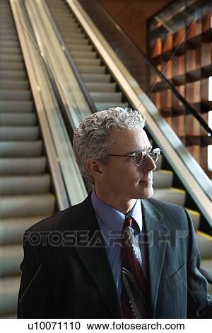 Close up of prime adult Caucasian man in suit on escalator. View Large Photo Image Stock Image - Close up of prime adult Caucasian man in suit on escalator.. Fotosearch