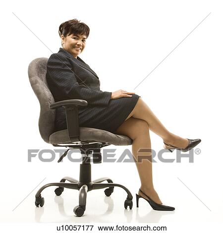 Filipino middle-aged businesswoman sitting in office chair against white background. View Large Photo Image Stock Photo - Filipino middle-aged businesswoman sitting in office chair against white background.. Fotosearch