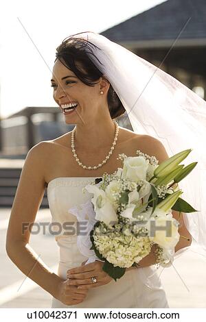 Caucasian mid-adult bride holding flower bouquet and smiling. View Large Photo Image Stock Image - Caucasian mid-adult bride holding flower bouquet and smiling.. Fotosearch
