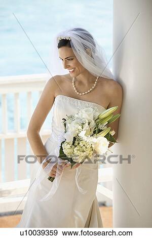 Caucasian mid-adult bride holding bouquet looking down. View Large Photo Image Stock Photo - Caucasian mid-adult bride holding bouquet looking down.. Fotosearch