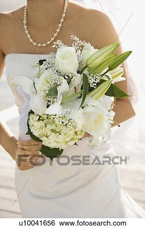 Caucasian mid-adult bride holding flower bouquet. View Large Photo Image Stock Photograph - Caucasian mid-adult bride holding flower bouquet.. Fotosearch