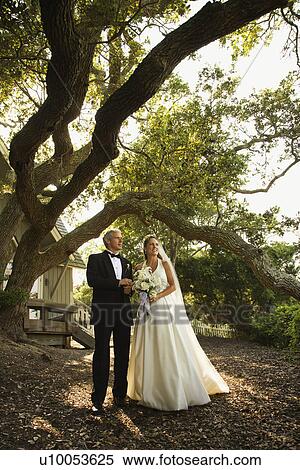 Mid-adult bride and groom standing outside of church. View Large Photo Image Stock Photography - Mid-adult bride and groom standing outside of church.. Fotosearch