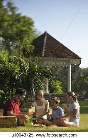 Stock Photography - Caucasian family of four having picnic in park.. Fotosearch